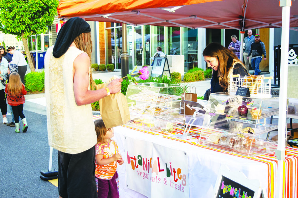 Samantha Falcone helps a customer at her booth, Botanical Eats, one of many options at the market. 